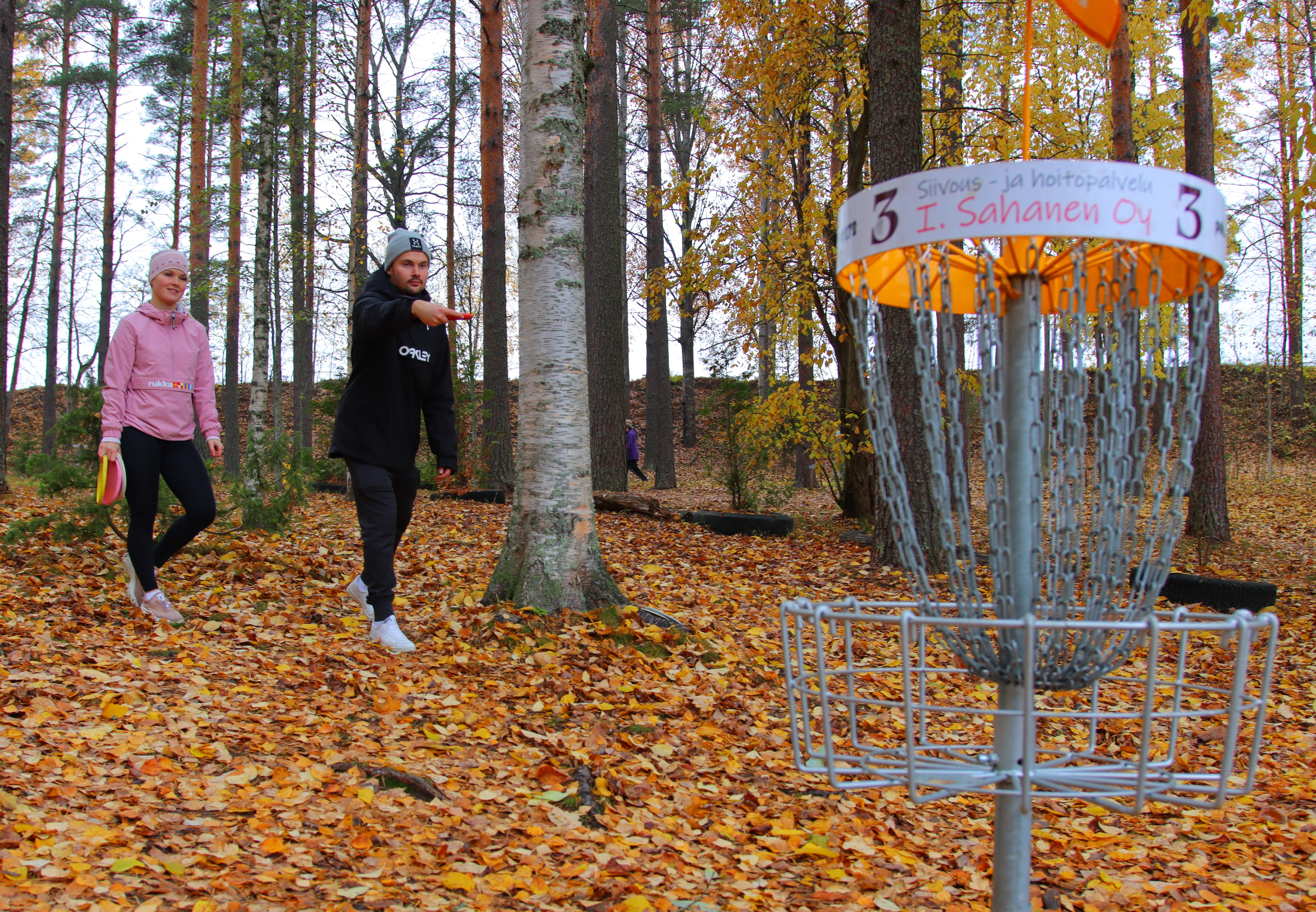 Frisbeekori ja kaksi heittäjää.